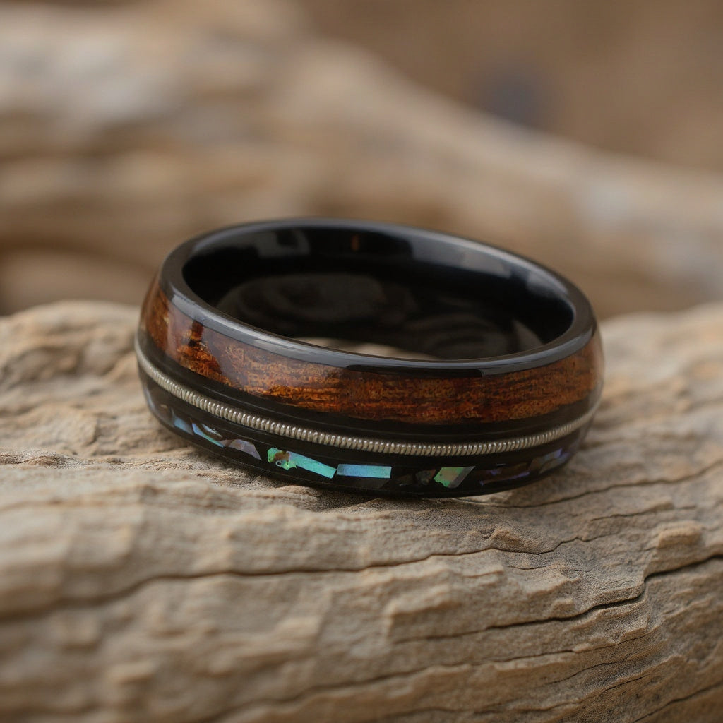 Cool Polished Black Tungsten Low Dome Ring with Silver Guitar String Between Iridescent Abalone And Whiskey Barrel Oak Wood Inlays.